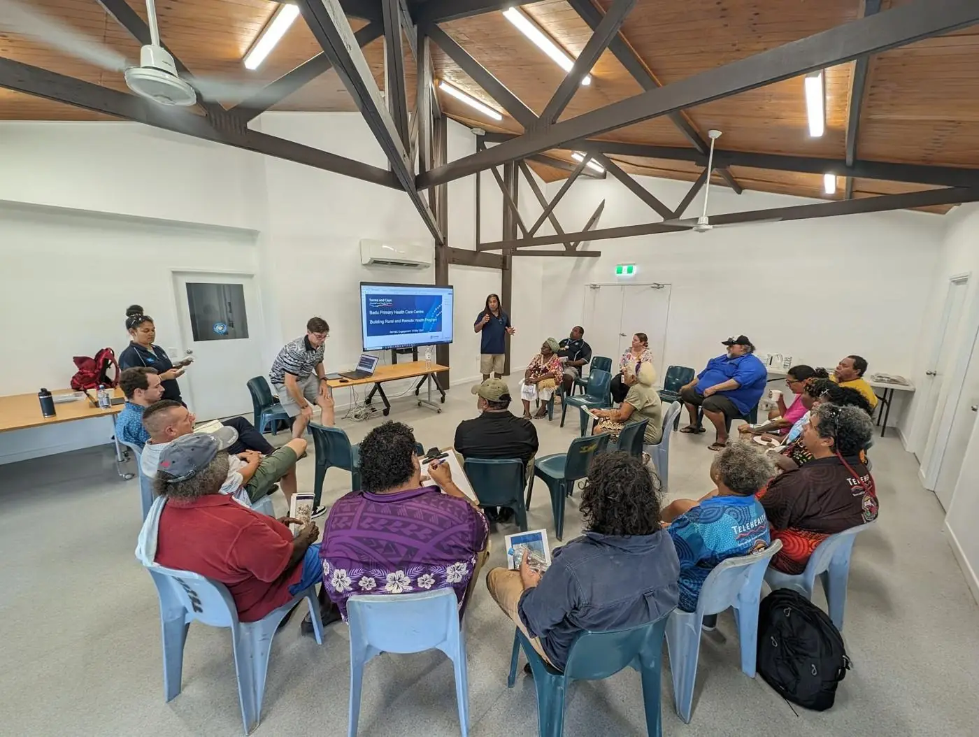 Workshop with Badu RNTBC members around tables facing a screen